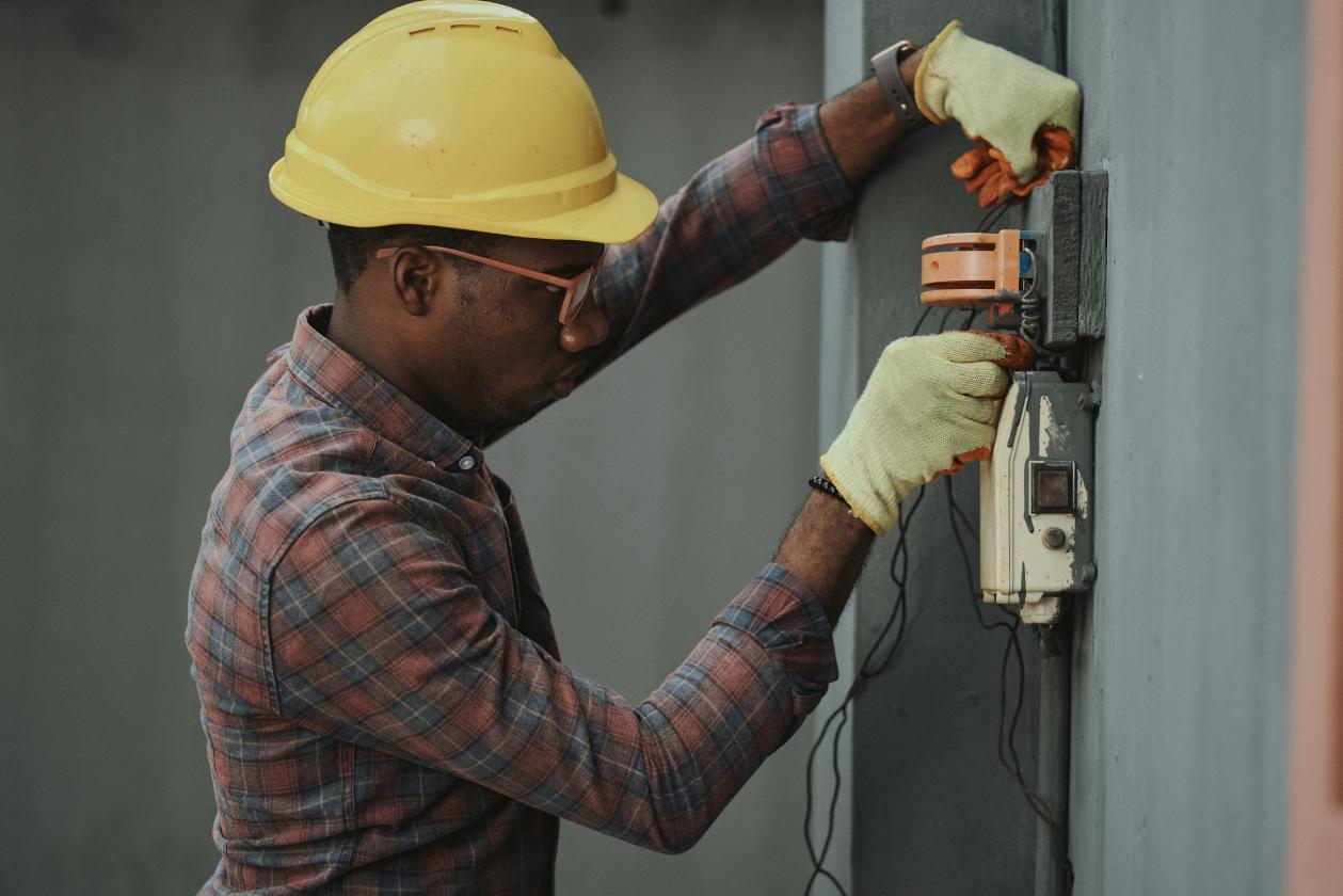 A person repairing an electric power panel