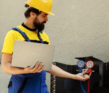 Mechanic calibrating pressure device Smiling competent mechanic calibrating pressure measurement device during comissioned air conditioner troubleshooting. Adept repairman reading vacuum pressure of condenser liquids and gases